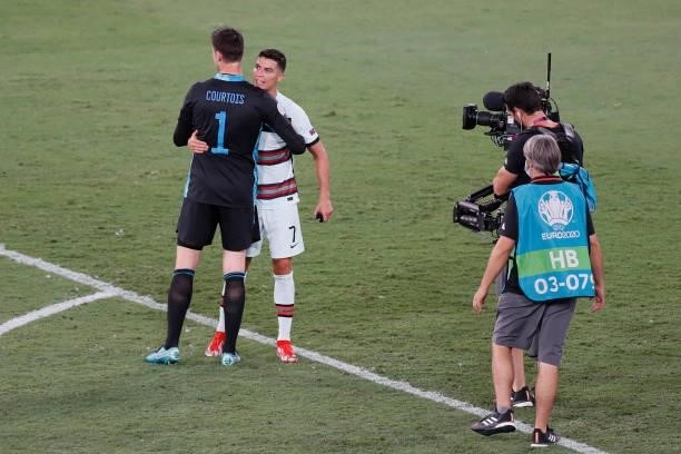 Belgium's goalkeeper Thibaut Courtois embraces Portugal's forward Cristiano Ronaldo after the UEFA EURO 2020 round of 16 football match between...