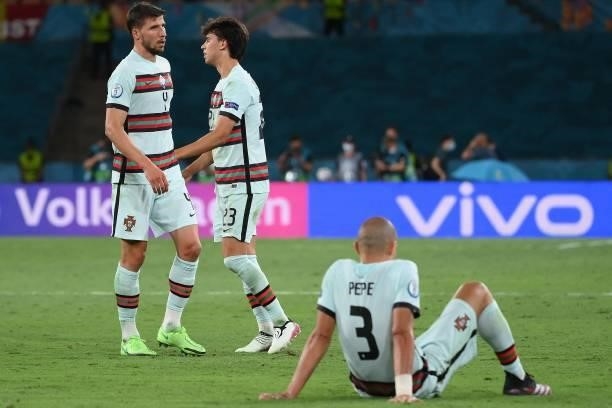 Portugal's defender Ruben Dias , Portugal's forward Joao Felix and Portugal's defender Pepe react to their defeat at the end of the UEFA EURO 2020...