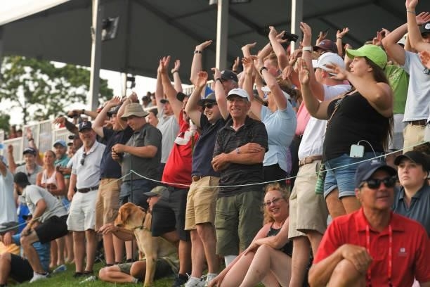 Fans do the wave around the 18th green during the eighth playoff hole during the final round of the Travelers Championship at TPC River Highlands on...