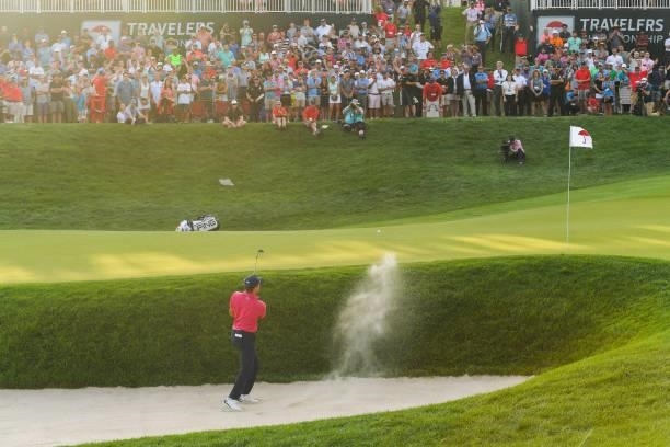 Kramer Hickok hits a shot from the bunker onto the 18th green during the fourth playoff hole during the final round of the Travelers Championship at...