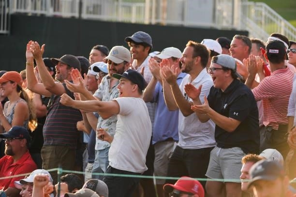 Fans cheer while watching play around the 17th green during the fifth playoff hole during the final round of the Travelers Championship at TPC River...