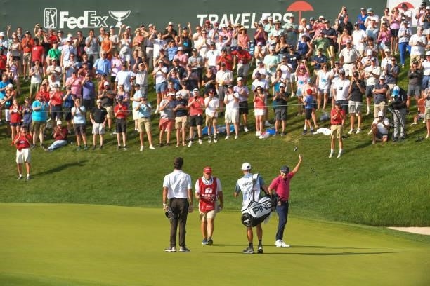 Kramer Hickok fist pumps while making a putt to tie the lead on the 18th green during the final round of the Travelers Championship at TPC River...