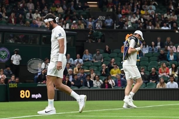 Georgia's Nikoloz Basilashvili passes Britain's Andy Murray as they swap ends during their men's singles first round match on the first day of the...