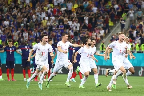 Switzerland's players run to celebrate after winning the UEFA EURO 2020 round of 16 football match between France and Switzerland at the National...
