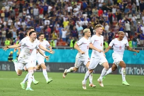 Switzerland's players run to celebrate after winning the UEFA EURO 2020 round of 16 football match between France and Switzerland at the National...