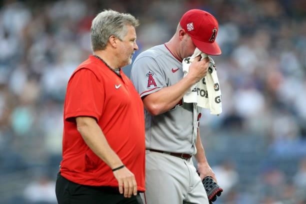 Dylan Bundy of the Los Angeles Angels is teken off the field after getting sick during the game between the Los Angeles Angels and the New York...