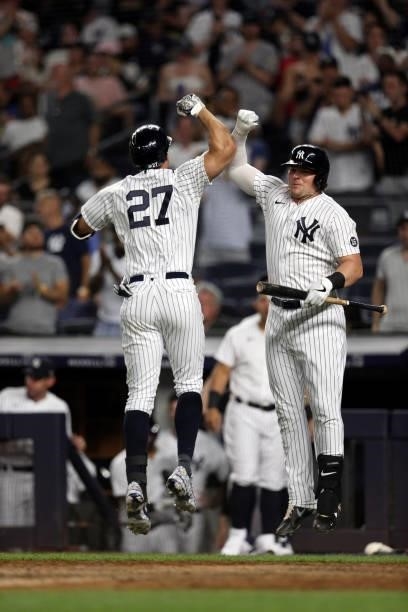 Giancarlo Stanton of the New York Yankees celebrates with Luke Voit after hitting a home run during the game between the Los Angeles Angels and the...