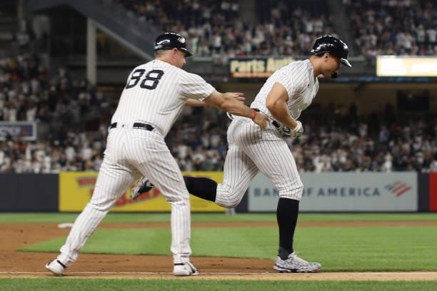 Giancarlo Stanton of the New York Yankees celebrates with Third Base Coach Phil Nevin after hitting a home run during the game between the Los...
