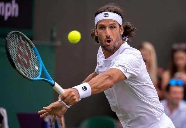 Spain's Feliciano Lopez returns against Britain's Daniel Evans during their men's singles first round match on the second day of the 2021 Wimbledon...