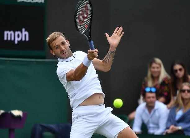 Britain's Daniel Evans returns to Spain's Feliciano Lopez during their men's singles first round match on the second day of the 2021 Wimbledon...