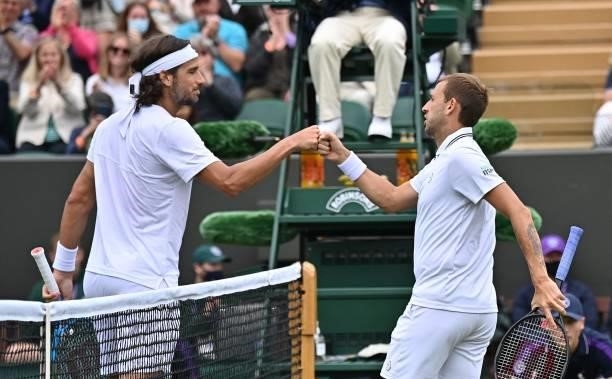 Britain's Daniel Evans bumps fists with Spain's Feliciano Lopez after winning their men's singles first round match on the second day of the 2021...