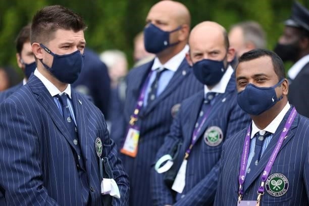 Match officials wearing a face covering to combat the spread of coronavirus, wait to enter courts on the second day of the 2021 Wimbledon...