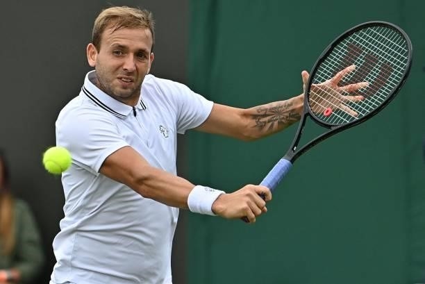 Britain's Daniel Evans returns to Spain's Feliciano Lopez during their men's singles first round match on the second day of the 2021 Wimbledon...