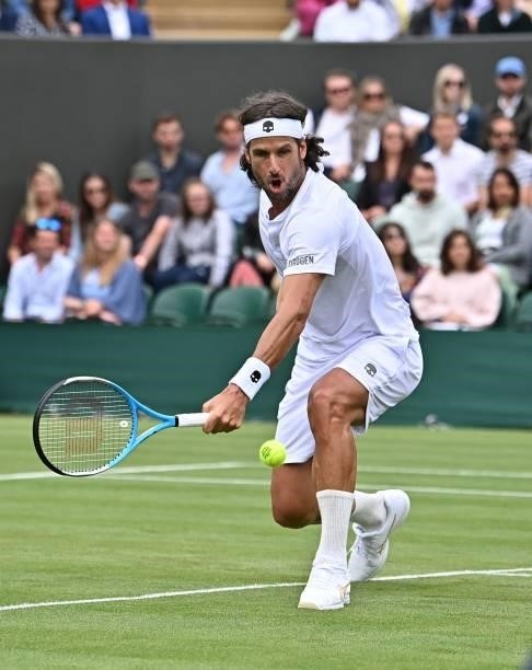 Spain's Feliciano Lopez returns to Britain's Daniel Evans during their men's singles first round match on the second day of the 2021 Wimbledon...