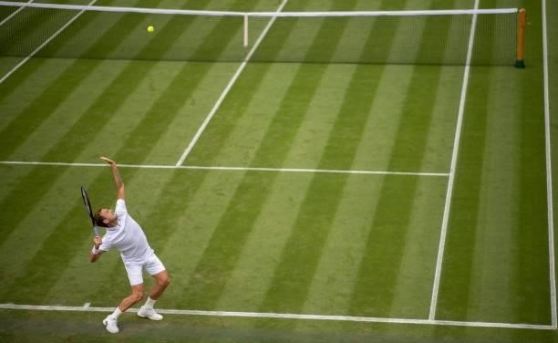 Britain's Daniel Evans serves to Spain's Feliciano Lopez during their men's singles first round match on the second day of the 2021 Wimbledon...