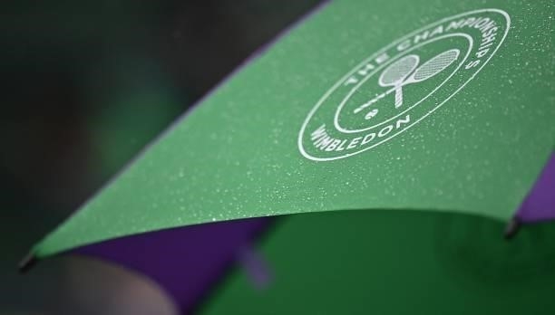 Wimbledon umbrella is covered in rain drops as spectators take cover on Court 2 during the second day of the 2021 Wimbledon Championships at The All...
