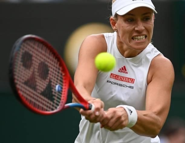Germany's Angelique Kerber returns to Serbia's Nina Stojanovic during their women's singles first round match on the second day of the 2021 Wimbledon...