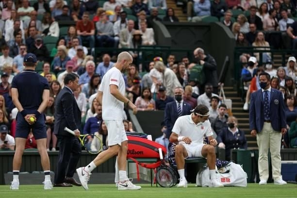 The umpire carries the racket of France's Adrian Mannarino , as he returns to his chair, before withdrawing from his men's singles first round match...