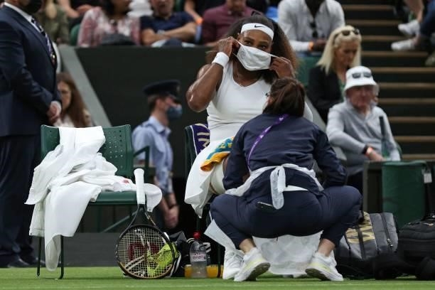 Player Serena Williams, puts on a face covering before leaving the court for treatment, during her women's singles first round match against...