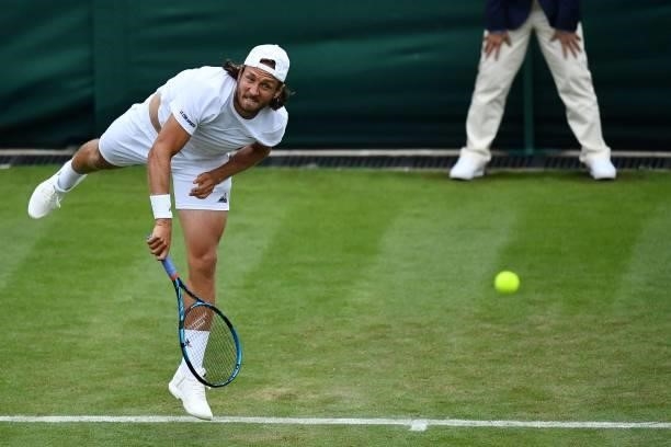 France's Lucas Pouille serves to Britain's Cameron Norrie during their men's singles first round match on the second day of the 2021 Wimbledon...