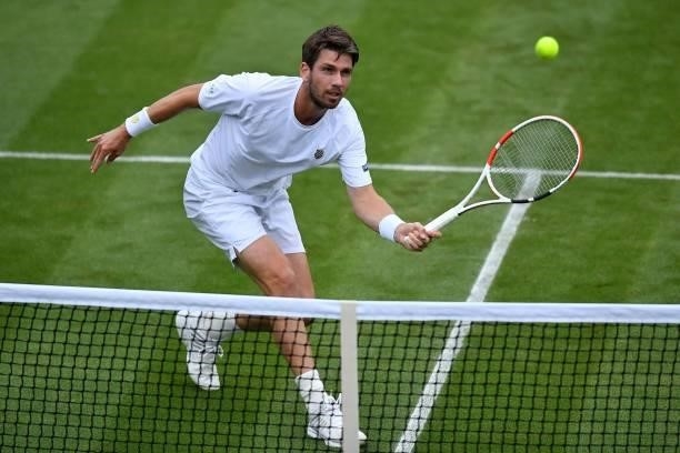 Britain's Cameron Norrie returns to France's Lucas Pouille during their men's singles first round match on the second day of the 2021 Wimbledon...