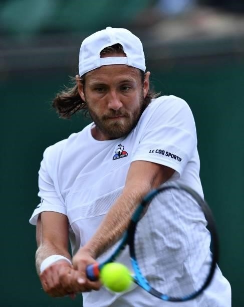 France's Lucas Pouille returns to Britain's Cameron Norrie during their men's singles first round match on the second day of the 2021 Wimbledon...