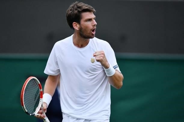 Britain's Cameron Norrie returns to France's Lucas Pouille during their men's singles first round match on the second day of the 2021 Wimbledon...