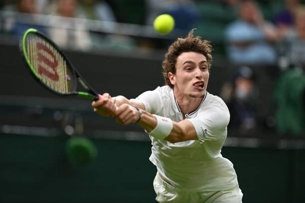 France's Ugo Humbert returns to Australia's Nick Kyrgios during their men's singles first round match on the second day of the 2021 Wimbledon...