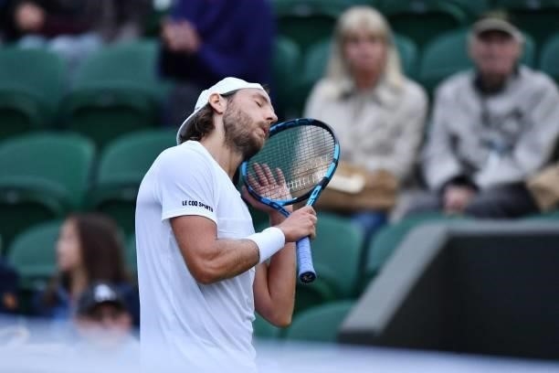France's Lucas Pouille gestures to finish play due to the light as he competes against Britain's Cameron Norrie in their men's singles first round...