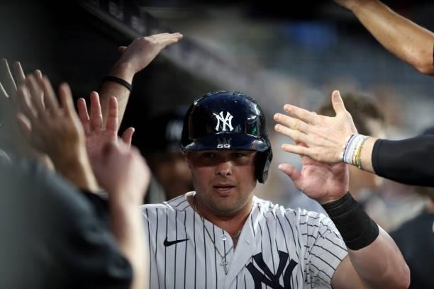 Luke Voit of the New York Yankees is greeted in the dugout after scoring a run in the fourth inning during the game between the Los Angeles Angels...
