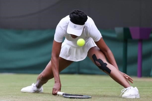 Player Venus Williams slips while playing Tunisia's Ons Jabeur during their women's singles second round match on the third day of the 2021 Wimbledon...