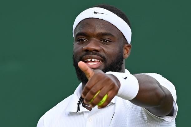 Player Frances Tiafoe reacts against Canada's Vasek Pospisil during his men's singles second round match on the third day of the 2021 Wimbledon...