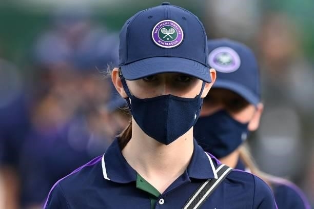 Ball-girls and Ball-boys wearing a face covering to combat the spread of coronavirus, walk between courts on the third day of the 2021 Wimbledon...