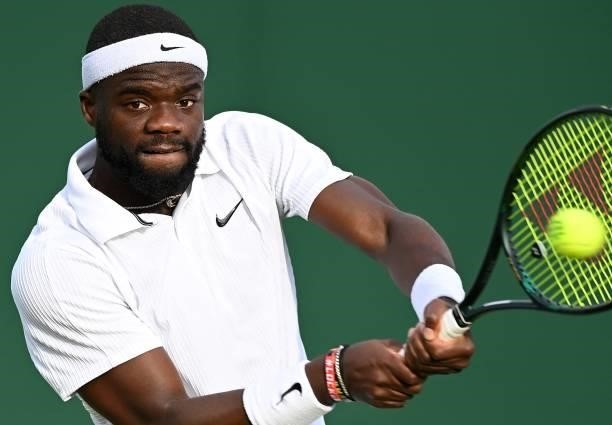 Player Frances Tiafoe returns against Canada's Vasek Pospisil during his men's singles second round match on the third day of the 2021 Wimbledon...
