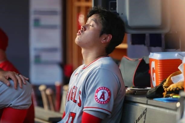 Shohei Ohtani of the Los Angeles Angels reacts in the dugout after leaving the game in the bottom of the first inning during the game between the Los...