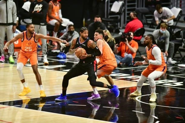 Paul George of the LA Clippers handles the ball as Devin Booker of the Phoenix Suns plays defense during the game during Game 6 of the Western...