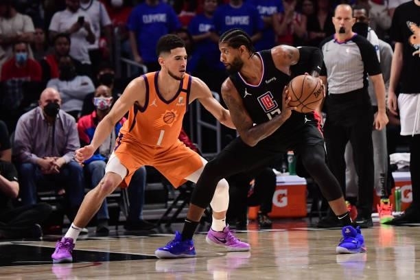 Devin Booker of the Phoenix Suns plays defense on Paul George of the LA Clippers during Game 6 of the Western Conference Finals of the 2021 NBA...