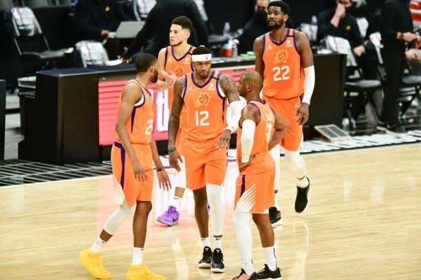 Torrey Craig of the Phoenix Suns talks to Mikal Bridges of the Phoenix Suns and Chris Paul of the Phoenix Suns during the game against the LA...
