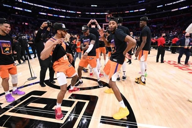 Cameron Payne, Torrey Craig of the Phoenix Suns and Mikal Bridges celebrate after winning the Western Conference Finals of the 2021 NBA Playoffs on...
