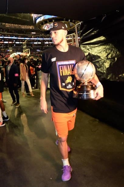 Devin Booker of the Phoenix Suns walks off the court with the Western Conference Finals trophy after Game 6 of the Western Conference Finals of the...
