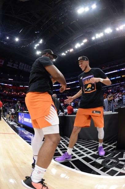 Chris Paul of the Phoenix Suns high fives Devin Booker of the Phoenix Suns after winning the Western Conference Finals of the 2021 NBA Playoffs on...