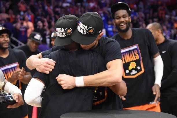 Devin Booker of the Phoenix Suns hugs Chris Paul of the Phoenix Suns after winning the Western Conference Finals of the 2021 NBA Playoffs on June 30,...