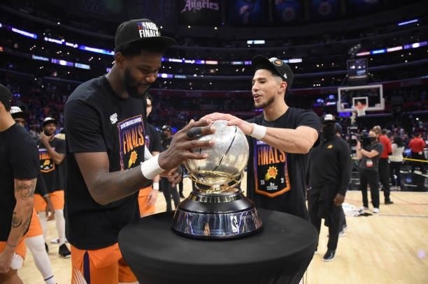 Deandre Ayton of the Phoenix Suns and Devin Booker of the Phoenix Suns touch the Western Conference Finals trophy after winning the Western...