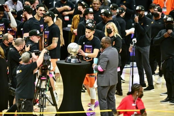 Devin Booker of the Phoenix Suns holds the Western Conference Finals Trophy after the game against the LA Clippers during Game 6 of the Western...
