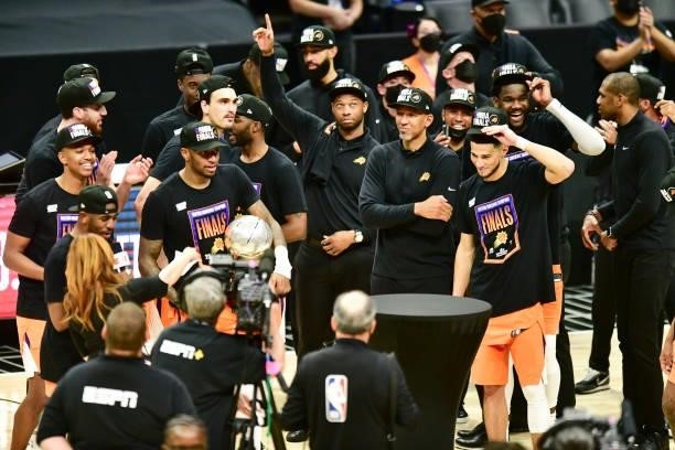 Torrey Craig of the Phoenix Suns holds the Western Conference Finals Trophy as Assistant Coach, Willie Green of the Phoenix Suns, Head Coach Monty...