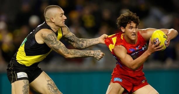 Wil Powell of the Suns is tackled by Dustin Martin of the Tigers during the 2021 AFL Round 16 match between the Gold Coast Suns and the Richmond...