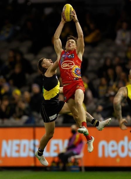 Ben Ainsworth of the Suns and Liam Baker of the Tigers compete for the ball during the 2021 AFL Round 16 match between the Gold Coast Suns and the...