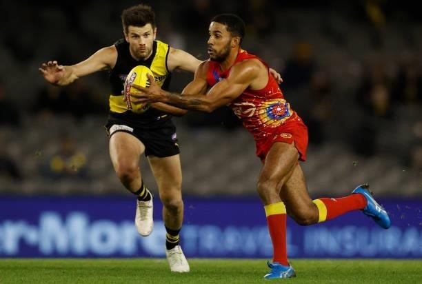 Touk Miller of the Suns is tackled by Trent Cotchin of the Tigers during the 2021 AFL Round 16 match between the Gold Coast Suns and the Richmond...