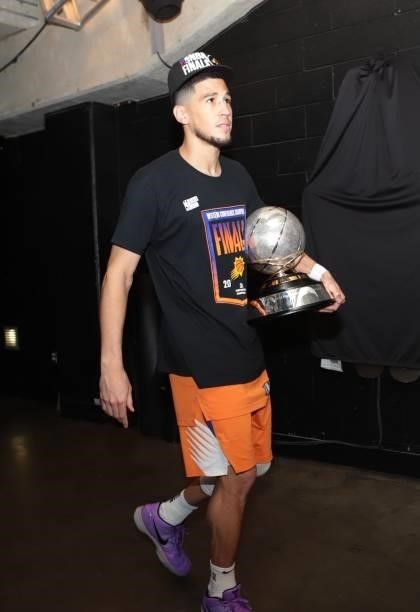 Devin Booker of the Phoenix Suns leaves the arena holding the Western Conference Finals Trophy after wining the Western Conference Finals of the 2021...