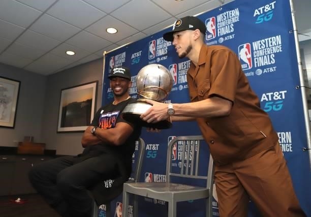 Devin Booker of the Phoenix Suns and Chris Paul hold the Western Conference Trophy after the game during Game 6 of the Western Conference Finals of...